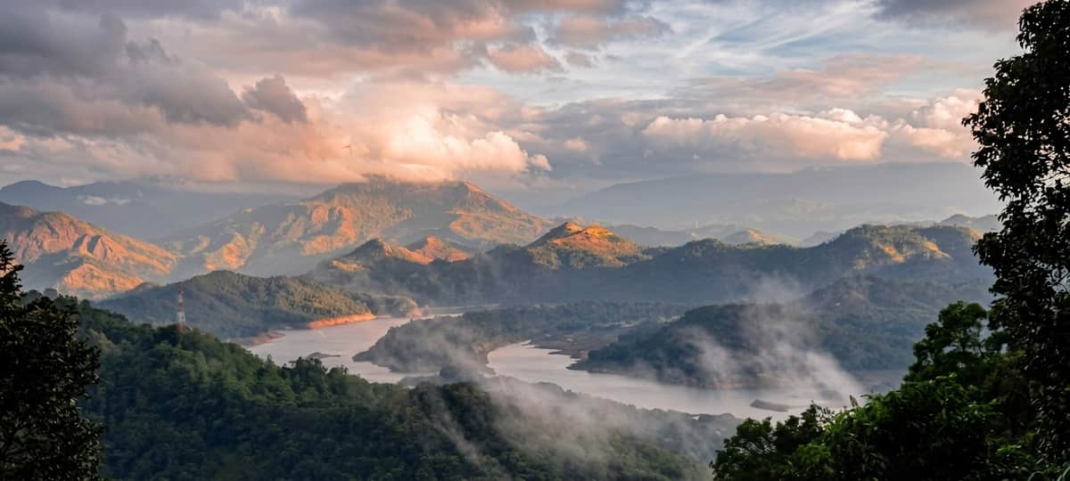 Cloud filling the valley below the estate at dawn, the mountains standing above it