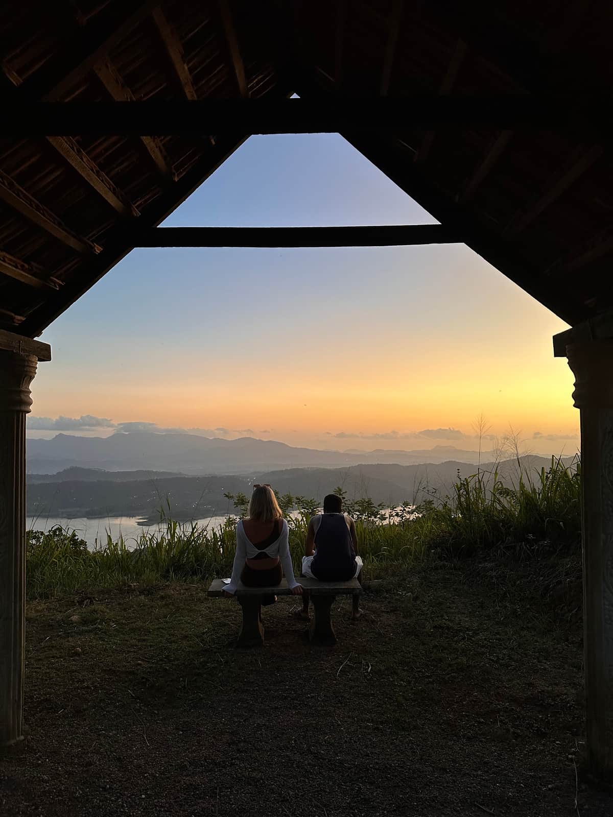 Two guests at the meditation spot, at the top of the estate, as the sun goes down