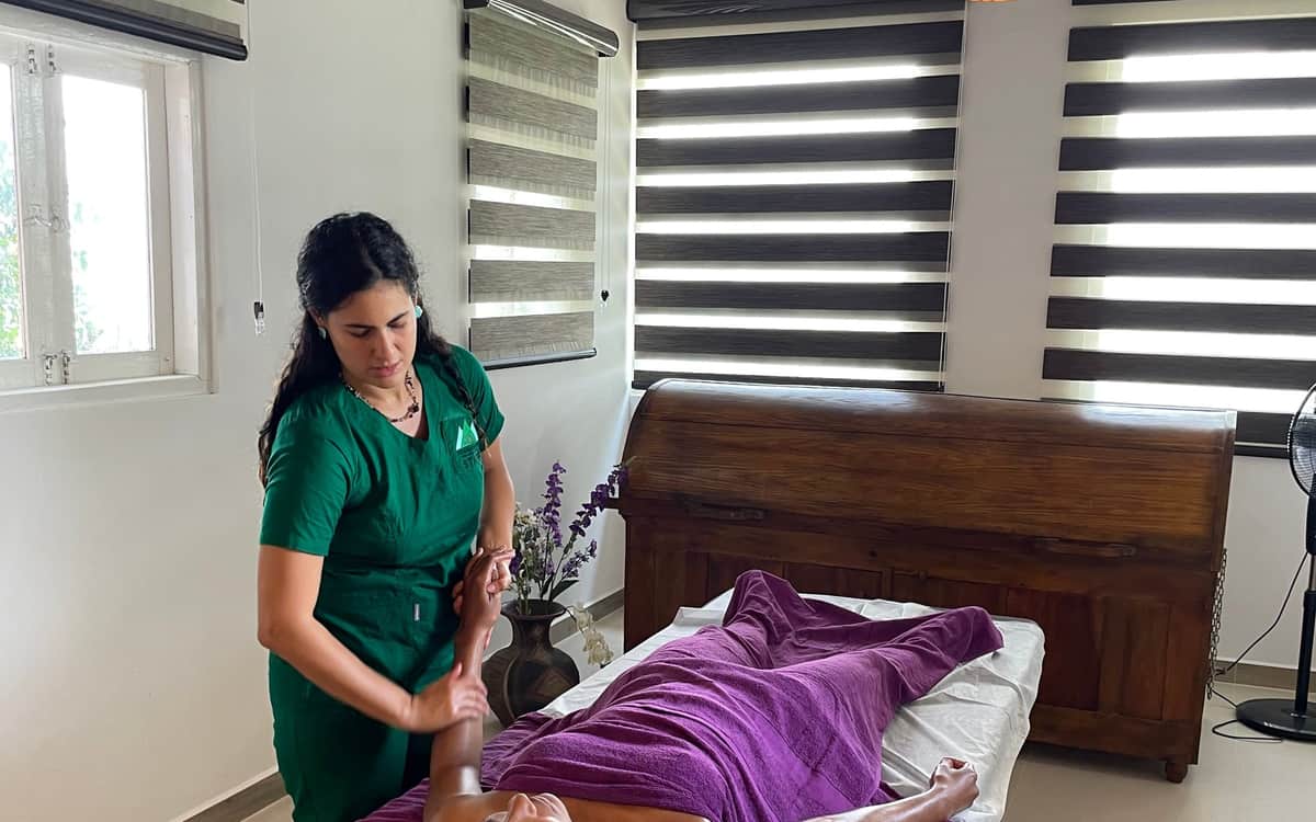 A therapist giving a full-body oil massage in the treatment room